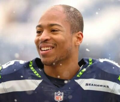 Lockett was born in the month in 1992 in Tulsa, Oklahoma, United States of America. Thirty years old American footballer celebrates his birthday every year on September 28. The wide receiver first appeared in the National Football league in 2015 A.D. The star Player has performed excellently every season since his first appearance in NPL. He has won several awards for exemplary performance in the game, such as Seattle Sports Star of the year (2021), Steve Largent Award Winner,  Emmy award, Walter Payton Man of the Year Award, and much more.  He finished the National Football League Season (2021) as the leading receiver with 57 receptions; hence on April 2, 2021, Tyler signed a $69.2 million contract extension with $37 million with the Seahawks on April 2, 2021. Is Tyler Lockett Christian? His Religion Explored  There has been a talk in the town about the famous American Footballer Religion; however, we have unfolded the mysteries about the start of footballer religion. Tyler Lockett is a Christian by birth, and he follows Christianity. The Popular player has not made any statements on his religion on any public media or platform; however, he was seen going to churches on several occasions. Therefore It states that Tyler has faith in Jesus Christ and Christianity. He often wears cross lockets during the game periods and outside the game. People believe that he wears The Cross locket to perform well in the game, and Guess what? – He has managed to deliver his best performance whenever he steps into the field. He finishes the National Football League Season (2021) as the leading receiver with 57 receptions; hence Tyler signed a $69.2 million contract extension with $37 million with the Seahawks on April 2, 2021. Tyler Lockett Family And Ethnicity Tyler’s father’s name is Kevin Lockett, whereas his mother is Nicole Edwards. Yes, you have heard it right. The famous American Football star Tyler Lockett’s father was a full-time wide-range receiver who played between 1993 to 1996 for Kansas State.  Tyler’s Father, Kevin Lockett, also played for the Kansas City Chiefs in National Football League. Kevin was the all-time leading receiver at the school-level game.  The star Footballer’s mother, Nicole Edwards, was a Sprinter with sheer tenacity.  Tyler Lockett is the eldest son of his family. He is more senior to the twin brother Jacob and Jordan Lockett.  The American Footballer’s grandparents, John Lockett and Beatrice Lockett were petroleum engineers; however, John was also involved in sports. John Lockett was also a sportsman who played basketball at Saint Augustine University. It is described that Tyler Lockett’s grandfather John Lockett played basketball on a Scholarship.  On the other hand, famous sportsman Tyler Lockett’s uncle- Aron Lockett, played at K-State. Aron was the fourth all-time leading receiver and Second all-time leading punt returner. He played for K- State from 1998-2001.  It appears that The Lockett family members are sportsmen by nature. The majority of the Lockett family members selected careers in sports and athletics. The athletic family’s ethnicity is Black, and it is assumed that they moved from Africa to America. Tyler Lockett Net Worth: According to wealthy Gorilla, the net worth of Tyler Lockett is around $ 11 Million. As per acknowledge, The Star footballer wide receiver’s monthly income is $0.1 million, whereas the monthly salary is $2 Million.  Lockett’s source of income includes Football Contract, brand endorsement, Real estate, and bonuses from the club team. Seattle Seahawks